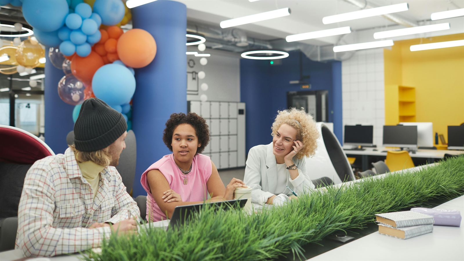 A team in discussion around a laptop in a modern workspace
