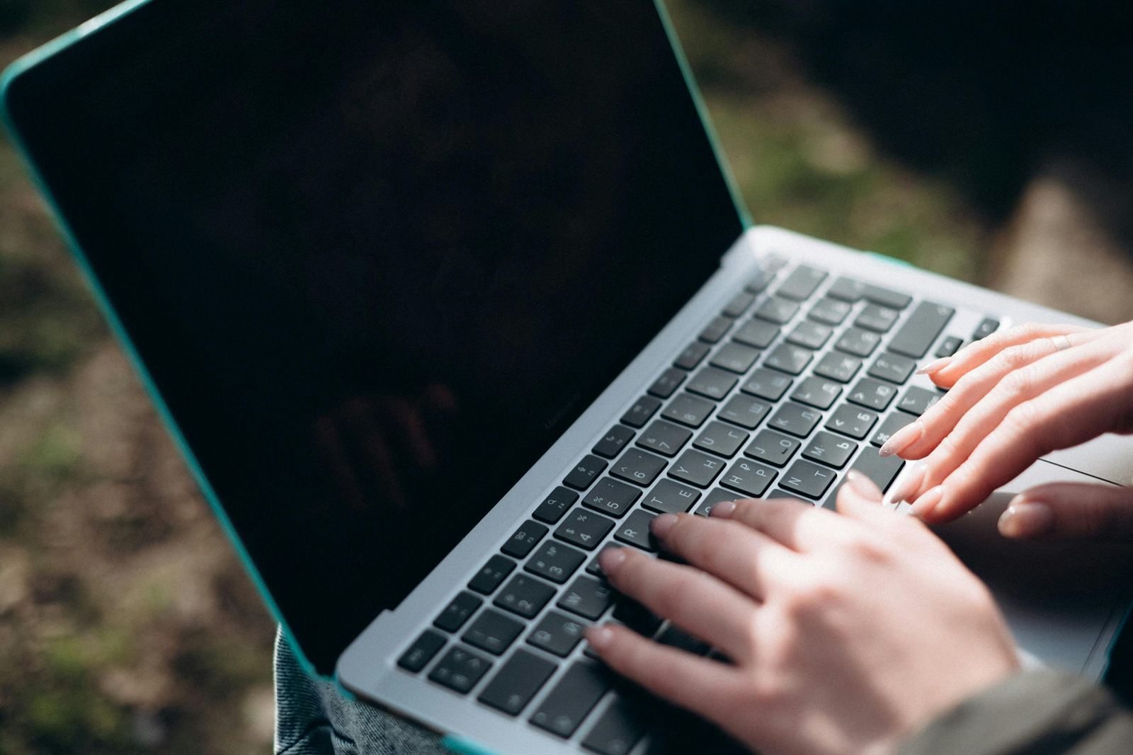 Hands typing on a laptop