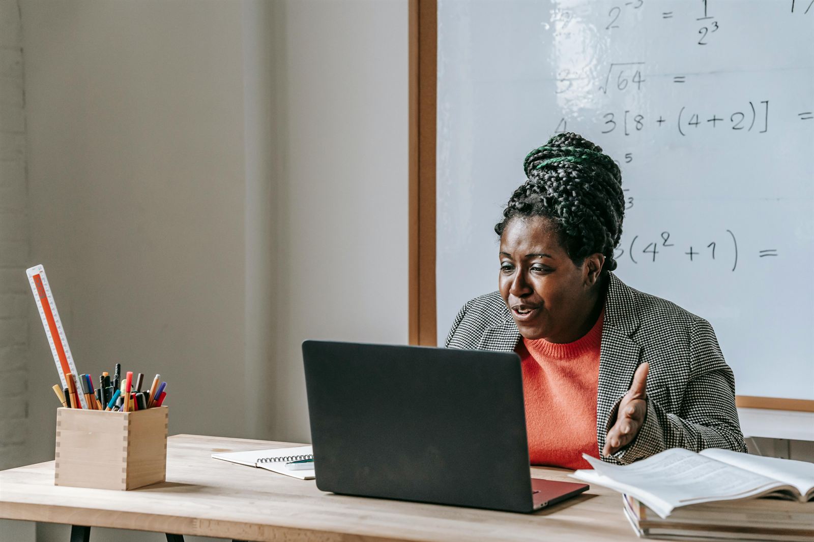 A teacher using a laptop at a whiteboard