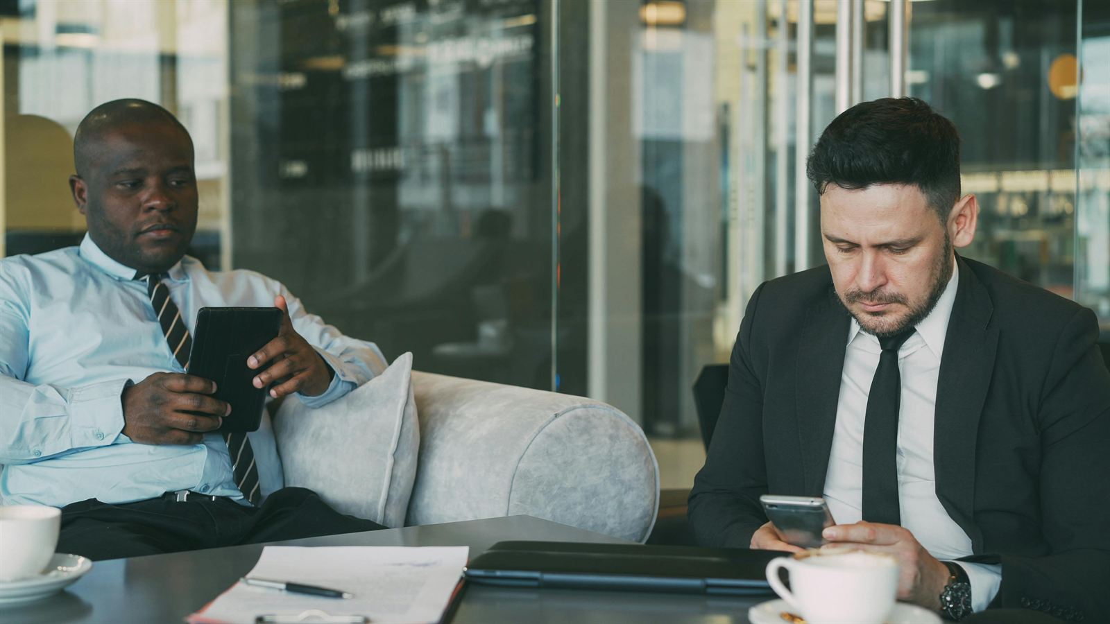 Two colleagues sitting apart, absorbed in their own devices
