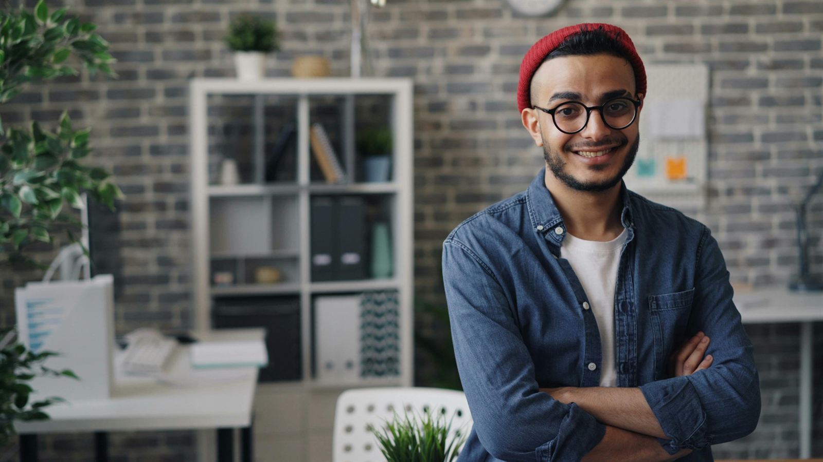A relaxed, confident employee smiling in an open-plan office