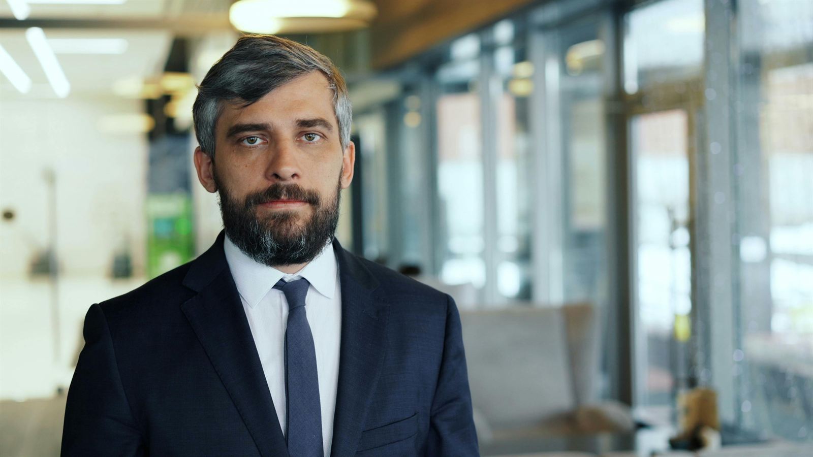 A composed leader standing in a modern office