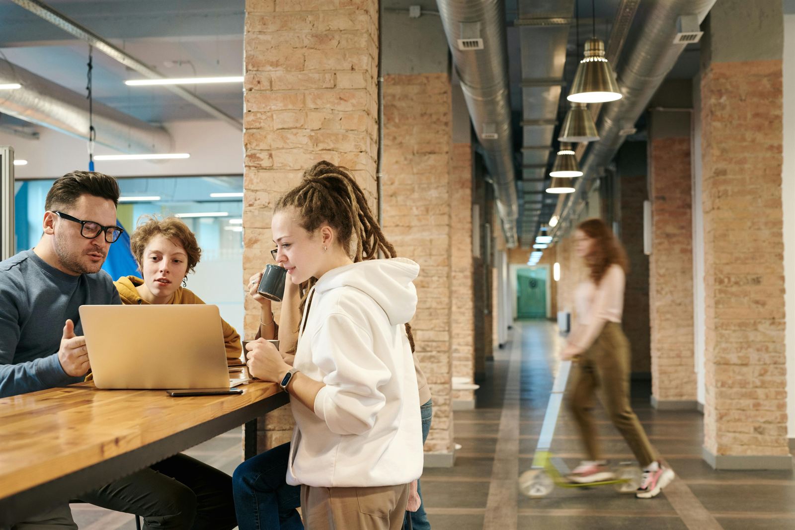 A team collaborating around a laptop in a coworking space